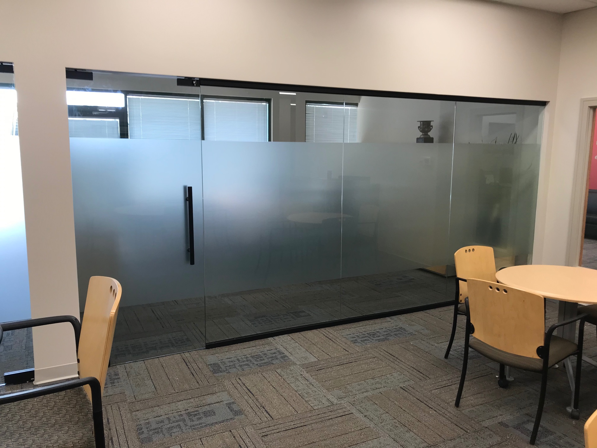 Frosted glass office partition with sliding door and black hardware, installed by Makibaki near Deerfield, IL