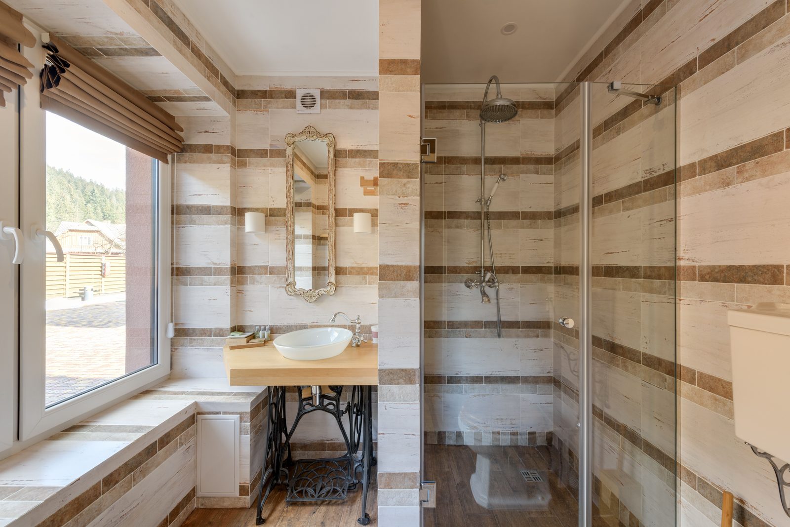 Glass shower door on a striped stone-tile walk-in shower, installed by Makibaki in the Deerfield, IL area