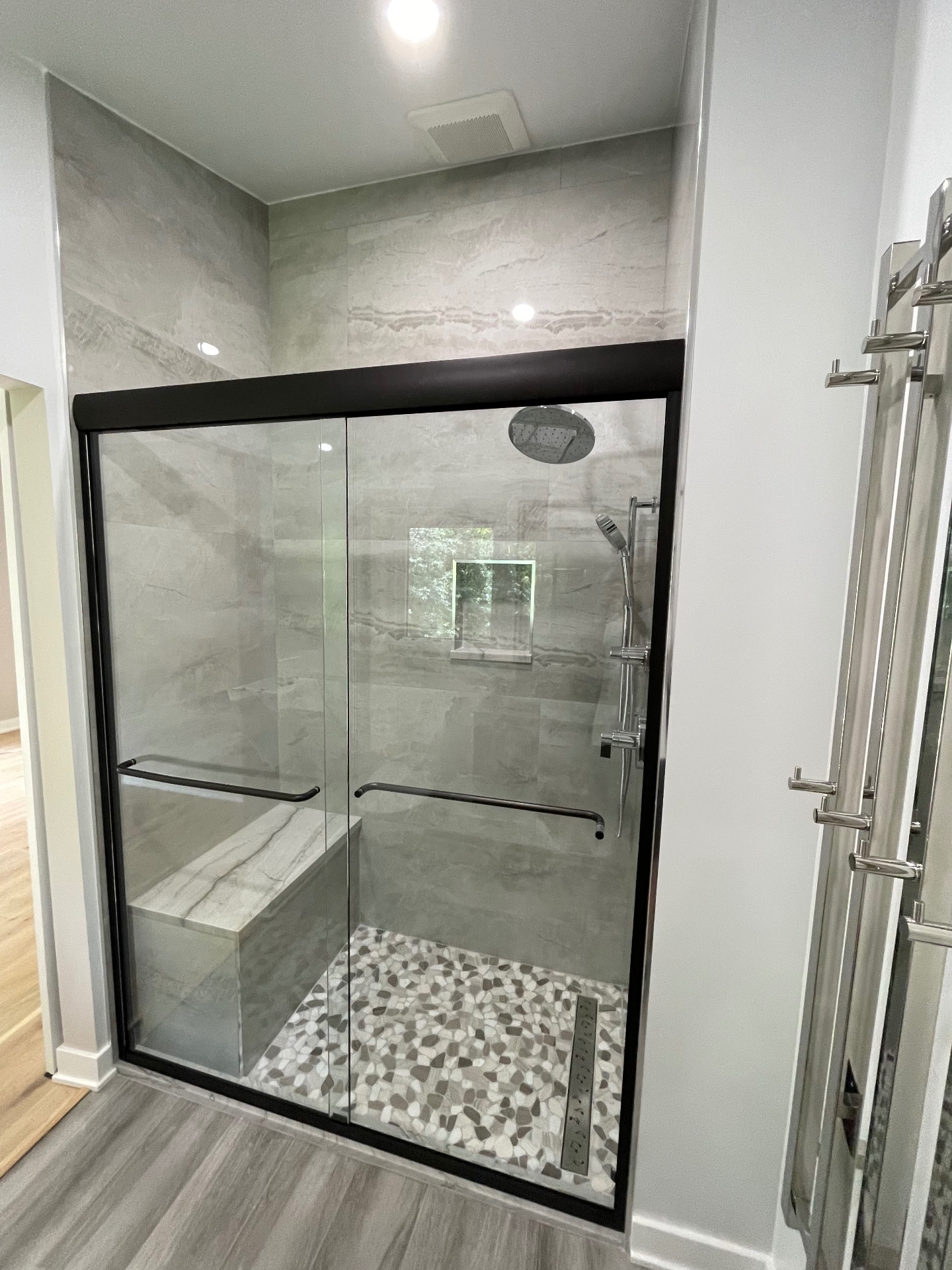 Frameless sliding shower door installed by Makibaki in a Hanover Park, IL bathroom